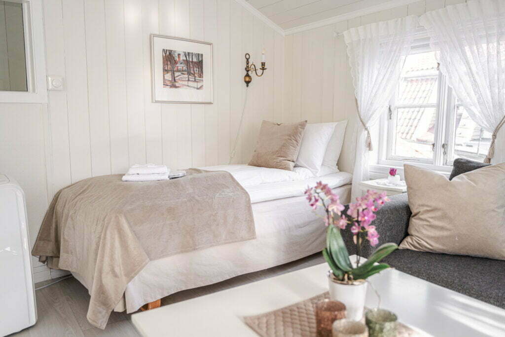 Bildet viser sovekrok i Holbergsuiten, hvor det er en seng i det ene hjørnet av rommet.