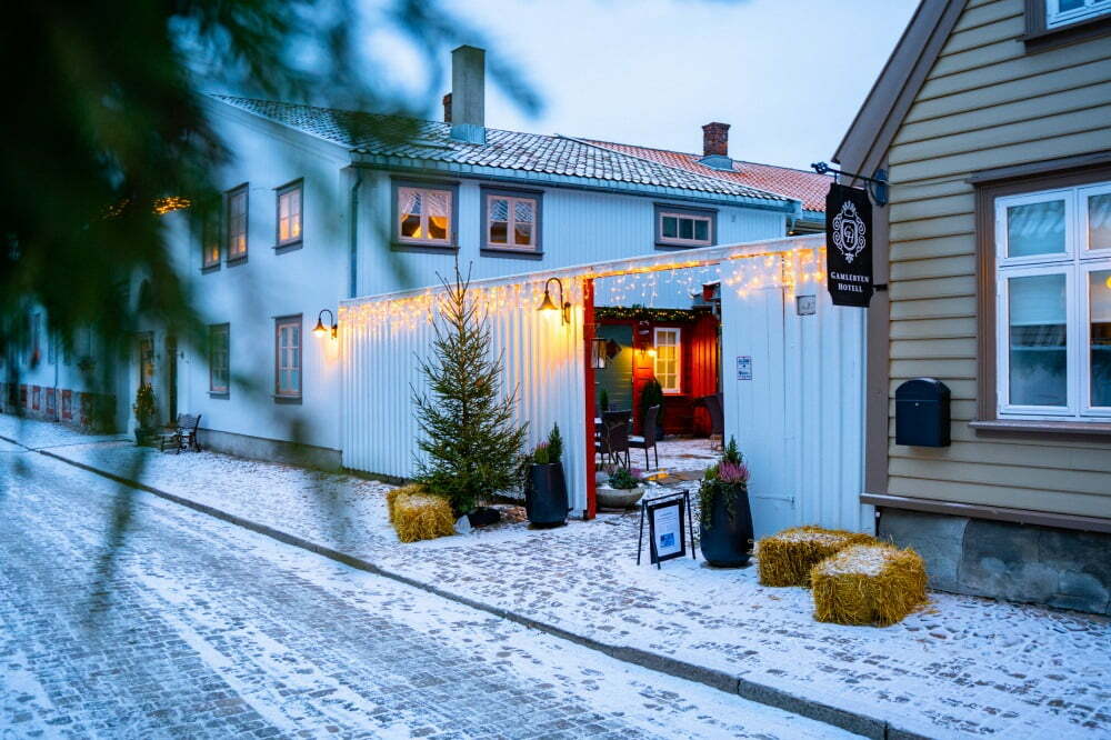 Bilde av Gamlebyen hotell på vinterstid, fasadebilde med julestemning og snø